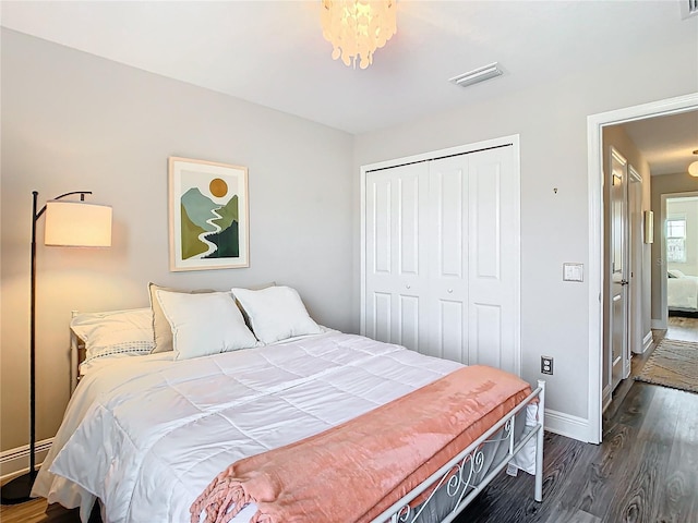 bedroom with dark hardwood / wood-style floors and a closet