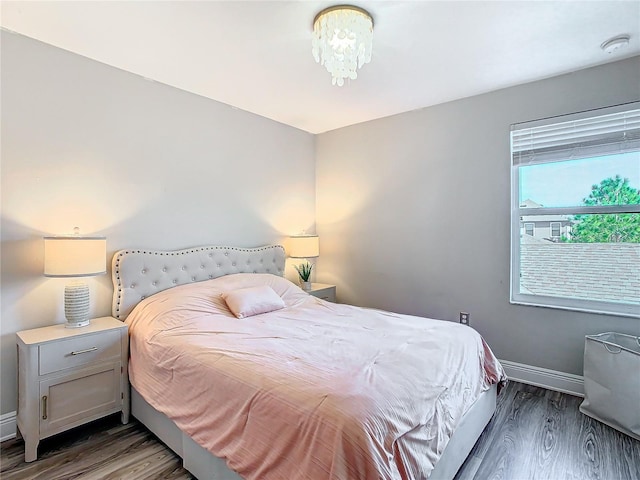 bedroom with a chandelier and dark hardwood / wood-style flooring