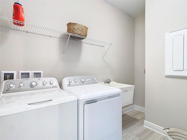 washroom featuring independent washer and dryer, electric panel, and sink