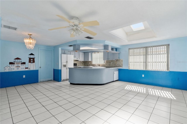 kitchen featuring light tile patterned flooring, white fridge with ice dispenser, ceiling fan with notable chandelier, decorative backsplash, and white cabinets