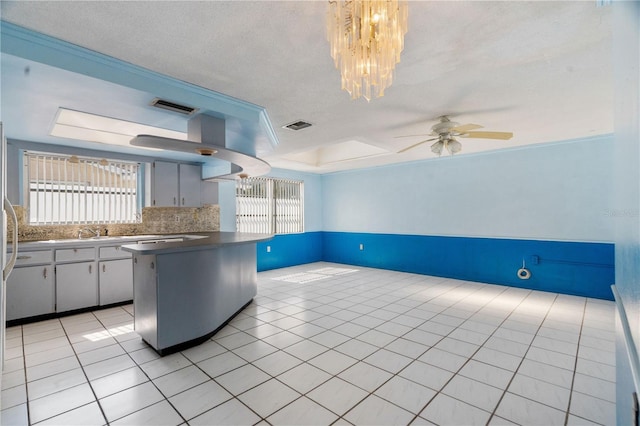 kitchen with plenty of natural light, a raised ceiling, decorative backsplash, and light tile patterned floors