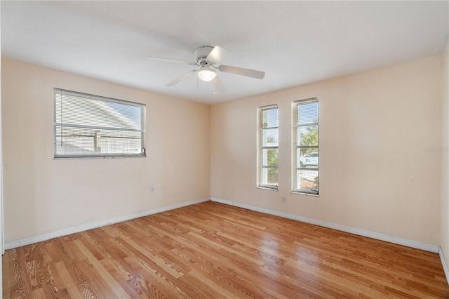 spare room featuring ceiling fan, a healthy amount of sunlight, and light wood-type flooring