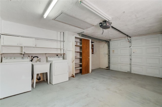 garage featuring sink, a garage door opener, and independent washer and dryer