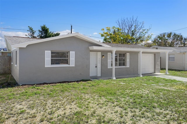 single story home featuring an attached garage, fence, driveway, stucco siding, and a front lawn