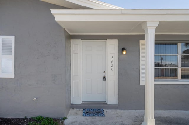 doorway to property with visible vents and stucco siding