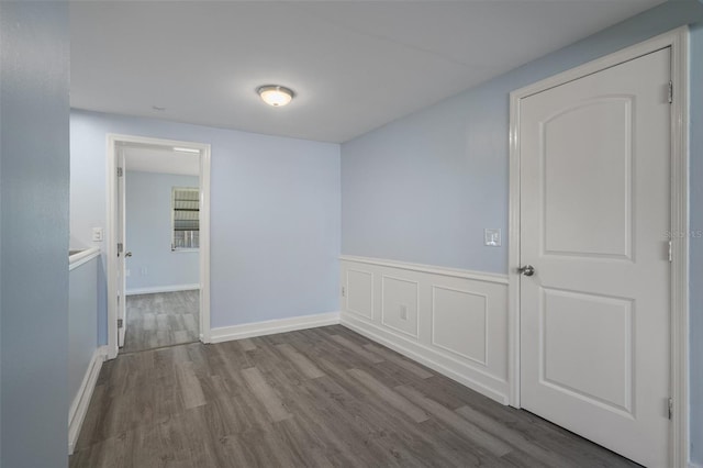 empty room with baseboards and wood finished floors