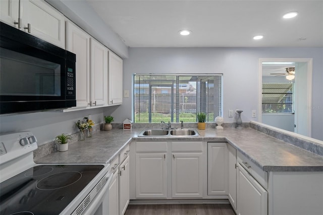 kitchen featuring black microwave, a sink, white electric range oven, and a healthy amount of sunlight