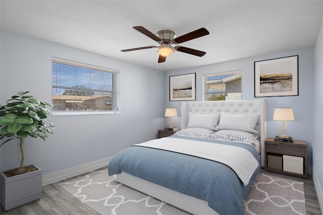 bedroom featuring ceiling fan, baseboards, and wood finished floors