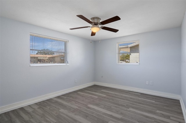 spare room featuring ceiling fan, wood finished floors, and baseboards