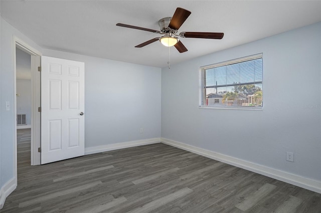 unfurnished room featuring ceiling fan, dark wood finished floors, visible vents, and baseboards