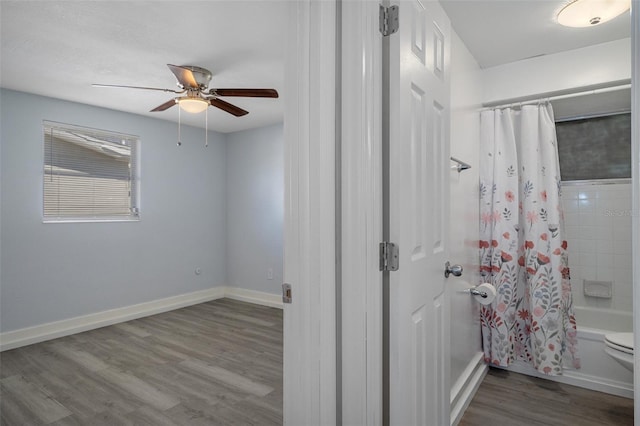 full bathroom featuring ceiling fan, toilet, wood finished floors, baseboards, and shower / tub combo with curtain