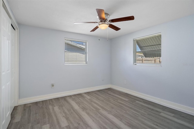 unfurnished room featuring ceiling fan, baseboards, and wood finished floors