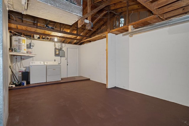 basement with electric water heater and washer and dryer