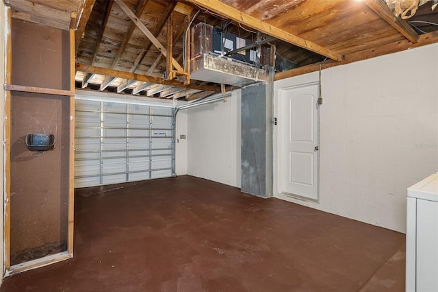 garage with washer / dryer and concrete block wall