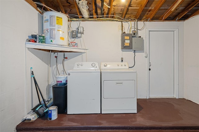 laundry room featuring concrete block wall, laundry area, electric panel, independent washer and dryer, and water heater