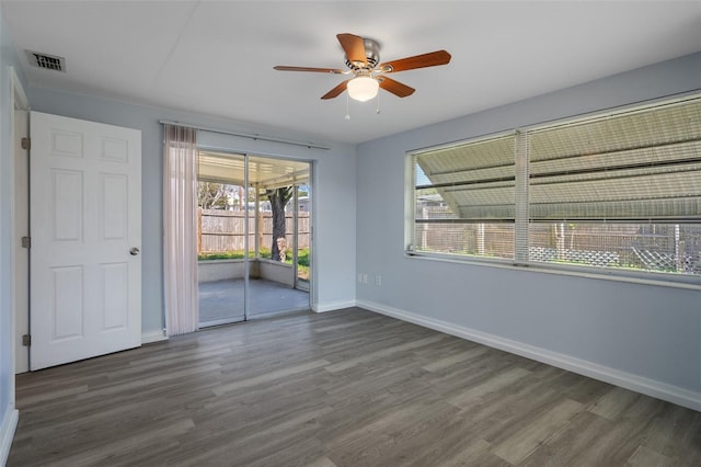 unfurnished room featuring a ceiling fan, visible vents, baseboards, and wood finished floors