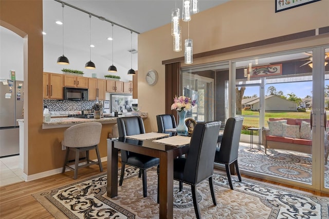 dining room featuring a high ceiling and light wood-type flooring