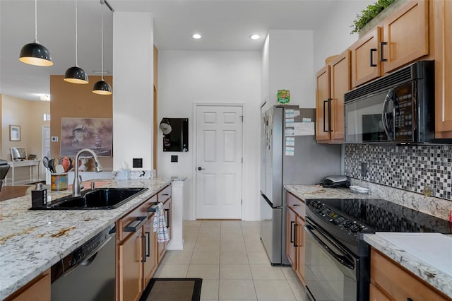 kitchen featuring sink, light tile patterned floors, backsplash, black appliances, and decorative light fixtures