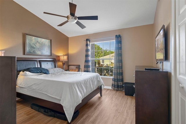 bedroom featuring ceiling fan, light hardwood / wood-style floors, and vaulted ceiling