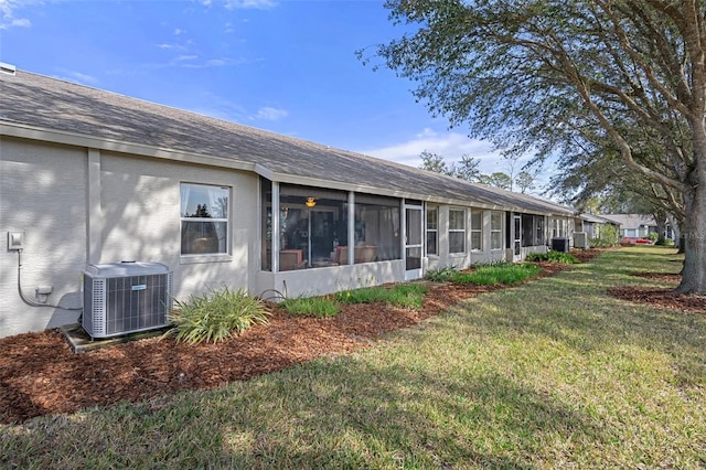 view of property exterior with cooling unit, a yard, and a sunroom