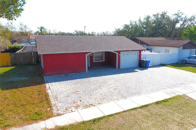 single story home with a garage and a front lawn