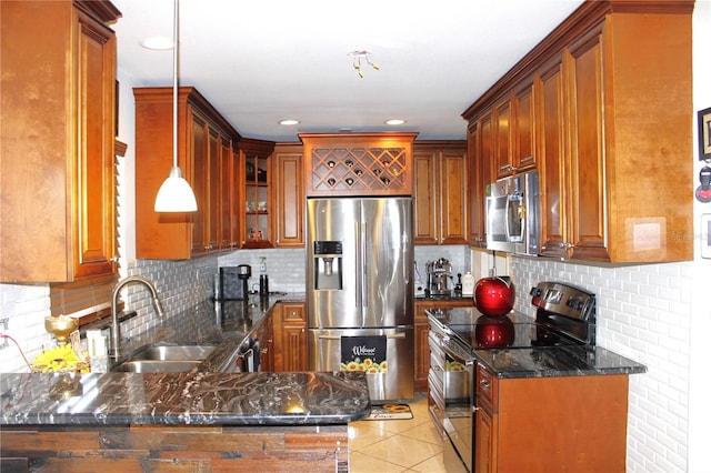 kitchen with sink, hanging light fixtures, light tile patterned floors, appliances with stainless steel finishes, and kitchen peninsula