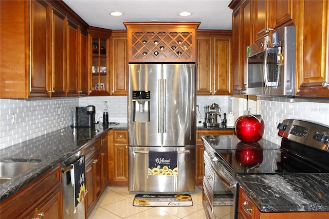 kitchen with light tile patterned flooring, appliances with stainless steel finishes, tasteful backsplash, and dark stone counters