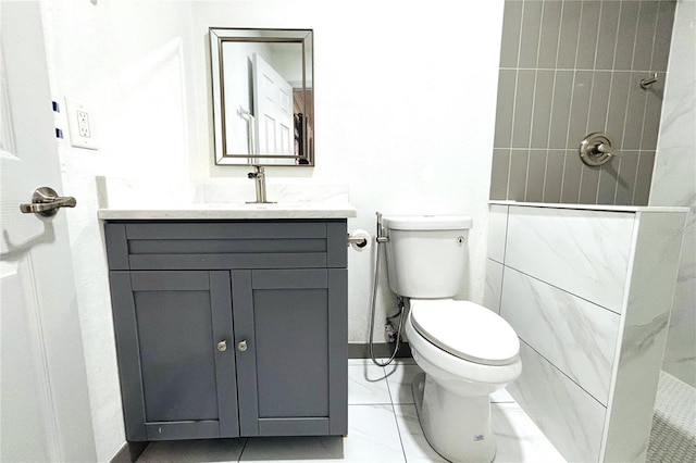 bathroom with tiled shower, vanity, and toilet