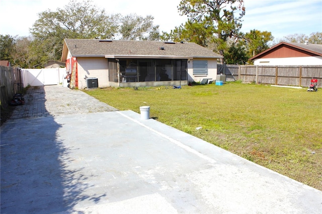 back of property featuring a sunroom, a lawn, and central air condition unit