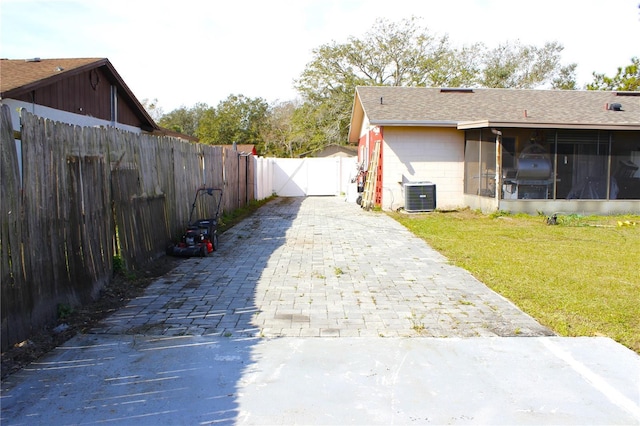 view of yard featuring a sunroom and central AC