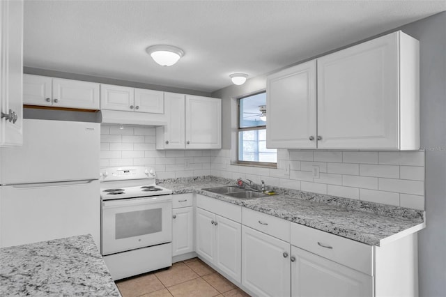 kitchen with sink, white appliances, light tile patterned floors, white cabinetry, and decorative backsplash