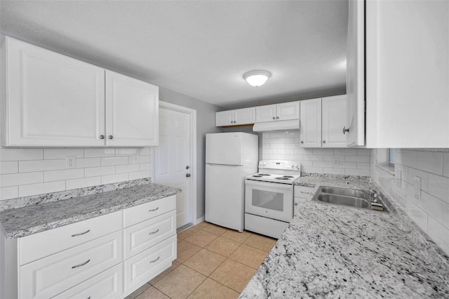 kitchen with sink, white appliances, light tile patterned floors, backsplash, and white cabinets