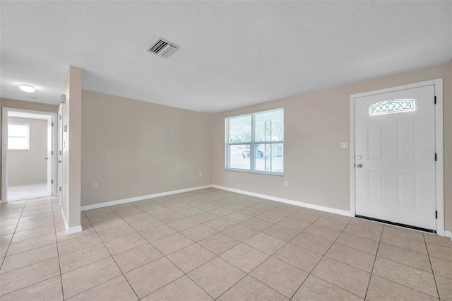 tiled entryway featuring a textured ceiling