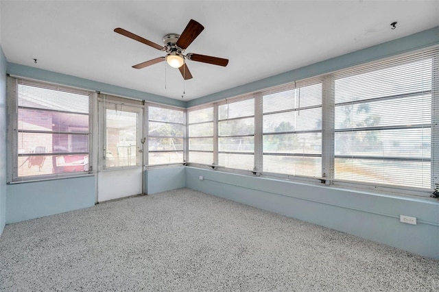 unfurnished sunroom featuring ceiling fan