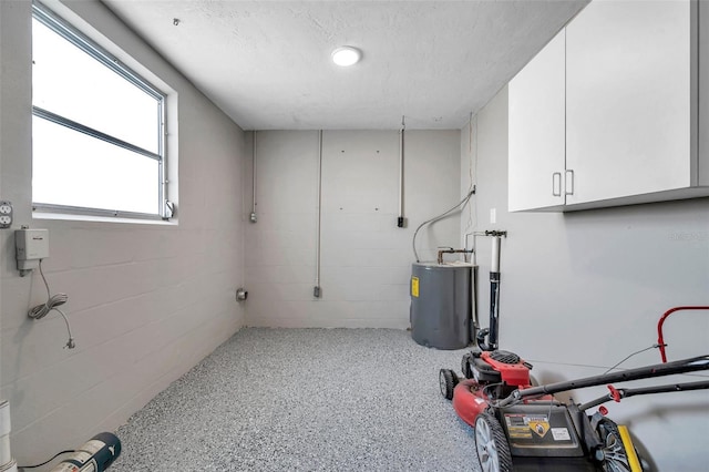 clothes washing area featuring electric water heater and a textured ceiling