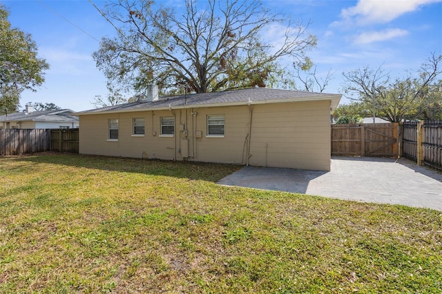 back of house featuring a patio area and a lawn