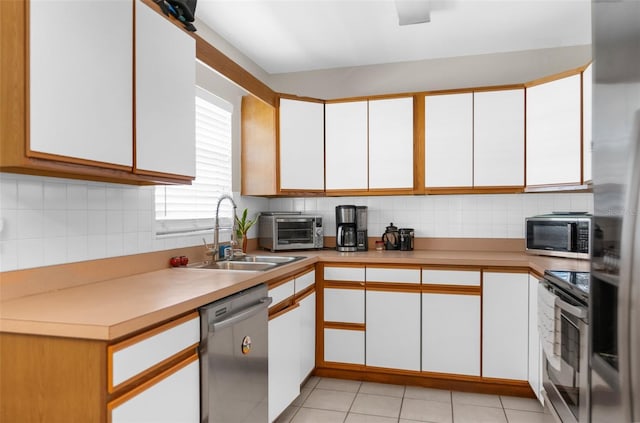 kitchen featuring backsplash, sink, white cabinets, and appliances with stainless steel finishes