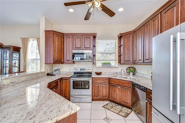 6801 Nowiki Ave, Hudson, FL 34667 - kitchen featuring light stone counters, appliances with stainless steel finishes, a ceiling fan, and a sink