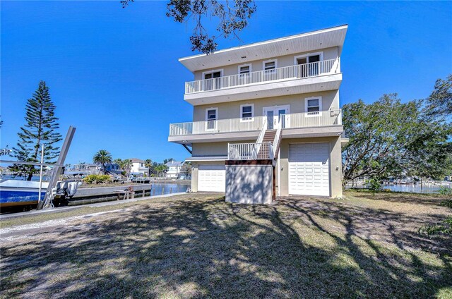 6801 Nowiki Ave, Hudson, FL 34667 - view of front of house with a garage, french doors, a water view, and a balcony