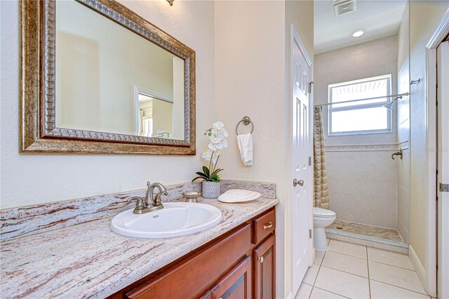 6801 Nowiki Ave, Hudson, FL 34667 - full bath with a tile shower, toilet, visible vents, tile patterned flooring, and vanity