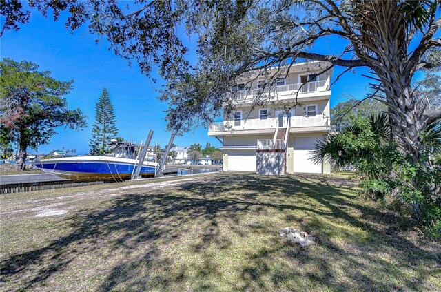 6801 Nowiki Ave, Hudson, FL 34667 - exterior space with an attached garage, a lawn, a balcony, and stucco siding