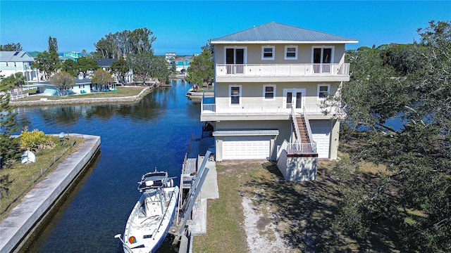 6801 Nowiki Ave, Hudson, FL 34667 - exterior space with a balcony, a water view, an attached garage, metal roof, and stairs