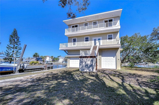 6801 Nowiki Ave, Hudson, FL 34667 - view of front of house with a garage, french doors, a water view, and a balcony