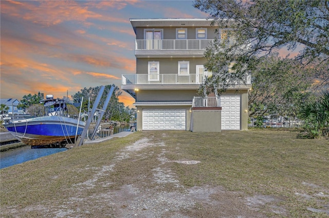 6801 Nowiki Ave, Hudson, FL 34667 - view of front facade with a balcony, a dock, driveway, boat lift, and stucco siding