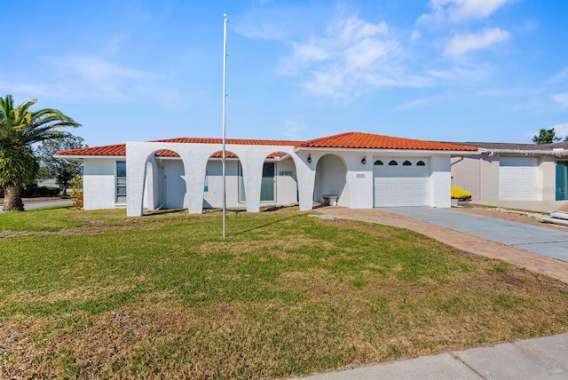 mediterranean / spanish-style home with a garage and a front lawn