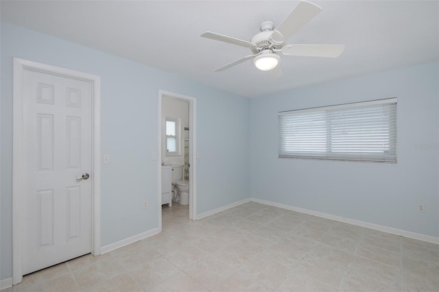 unfurnished bedroom featuring light tile patterned flooring, ensuite bathroom, and ceiling fan