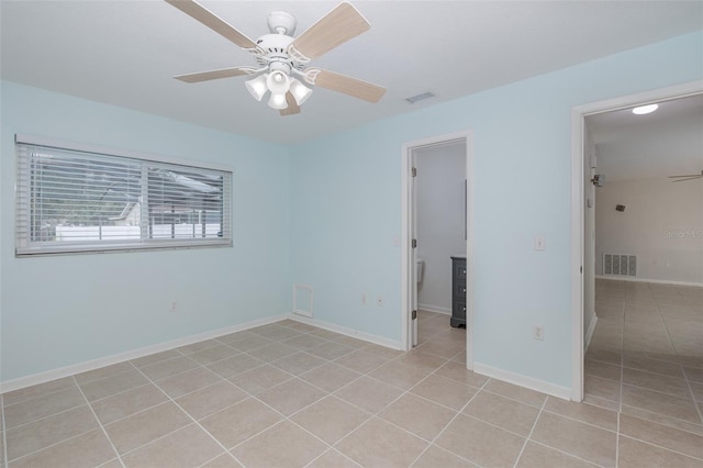 tiled spare room featuring ceiling fan