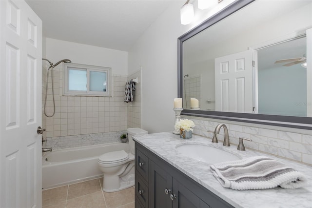 full bathroom featuring tiled shower / bath, vanity, ceiling fan, toilet, and tile patterned floors