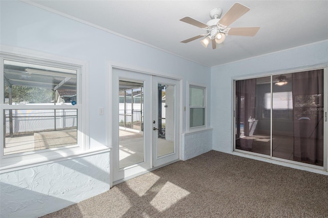 unfurnished sunroom featuring ceiling fan and french doors