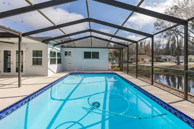 view of pool featuring french doors, a water view, glass enclosure, and a patio area